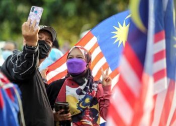 ORANG ramai bergambar sempena Sambutan Hari Kebangsaan 2021 di Putrajaya, hari ini. - UTUSAN/FAISOL MUSTAFA