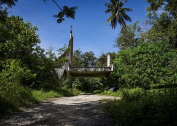 KEADAAN laluan masuk utama Taman Tema Mimaland yang popular pada tahun 1971 hingga ia ditutup pada 1994 yang kini terbiar serta dilitupi hutan di Jalan Gombak-Bentong, Selangor. - UTUSAN/MUHAMAD IQBAL ROSLI