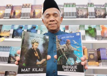ABDUL LATIP Talib menunjukkan dua judul bukunya yang paling laris pada Pesta Buku Melaka 2022 iaitu Mat Kilau dan Enrique Melaka yang berharga RM40 sebuah. - UTUSAN/MUHAMMAD SHAHIZAM TAZALI