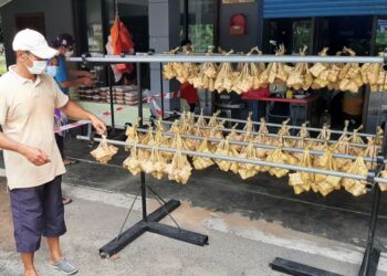 MOHD. YUSRI Mahat sudah berniaga menjual ketupat bawang sejak lebih 20 tahun di Kampung Padang, Pokok Mangga, Melaka. - UTUSAN/AMRAN MULUP