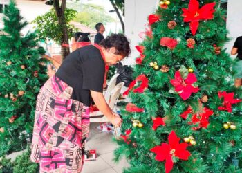 PENDUDUK Kampung Portugis, Ujong Pasir, Melaka bergotong-royong menghias pentas sempena sambutan Krismas pada 25 Disember ini. -UTUSAN/AMRAN MULUP