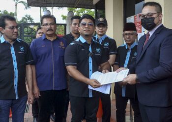 HISHAMMUDDIN Hashim (tengah) menyerahkan memorandum kepada wakil pegawai Kementerian Luar Negeri, Nazeem Hambali (kanan) berhubung kes warga Malaysia yang dipenjara seumur hidup di Bangladesh di Wisma Putra. - UTUSAN/FAISOL MUSTAFA