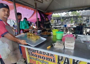 MOHD. Ghazali Hussin menunjukkan murtabak ekonomi yang dijualnya dengan harga RM1 di bazar Ramadan Kelang Lama di Kulim, Kedah. - FOTO/AZAHAR HASHIM