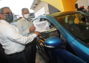 MUSTAPA Mohamed (dua kiri) menyerahkan sumbangan bakul makanan kepada pemandu e-hailing secara pandu lalu pada Majlis Program Pemberian Bakul Makanan kepada Pekerja Gig Ekonomi dan bekas petugas media di Putrajaya Sentral. -UTUSAN/ FAISOL MUSTAFA