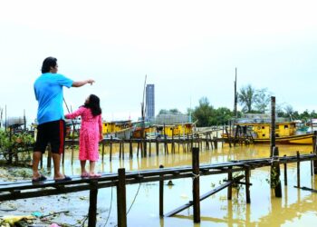 FAZRUL Nizam Kamal Bashah ditemani anaknya melakukan tinjauan bot-bot nelayan tidak ke laut di Jeti Tanjung Api di Kuantan, Pahang, semalam. - UTUSAN/AJIE MUSTAFA