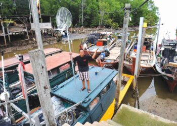 CHAN Kam Meng menunjukkan keadaan Jeti Kampung Kuala Lukut Kecil, Port Dickson yang sunyi tanpa kehadiran nelayan ekoran ikan yang dikatakan semakin berkurangan di sepanjang kawasan tangkapan di perairan Port Dickson. – UTUSAN/MOHD. SHAHJEHAN MAAMIN