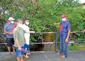 PHILIPS Gomez (dua dari kiri) dan beberapa orang penduduk menunjukkan longkang yang tidak diselenggara dengan baik sehingga menjadi punca kepada kejadian banjir ketika ditemui di Taman Mok Sum, Rasah, Seremban semalam.-UTUSAN/ZAKKINA WATI AHMAD TARMIZI.