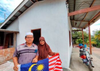 ARIS Md. Nor dan Ruzilawati terharu dan bersyukur apabila kediaman papan yang dibina pada tahun 1964 berubah menjadi binaan batu menerusi Projek Jiwa Murni, Kementerian Pertahanan di Felda Bukit Jalor, Tampin, hari ini.-UTUSAN/NOR AINNA HAMZAH