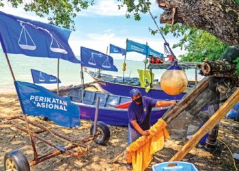 Penduduk Pantai Padang Kemunting, Hairul Abu Kasim melakukan persiapan dengan mengangkat tungko sebelum menangkap ikan di Pengkalan Balak, Melaka, semalam.  – UTUSAN/AMIR KHALID