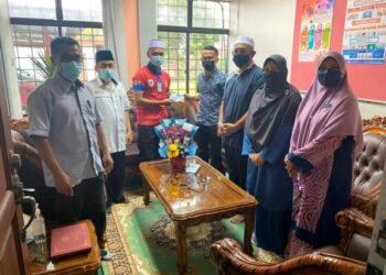 AHMAD Haziq Fadzil (tiga dari kiri) menerima sumbangan wang tunai yang disampaikan Pusat Khidmat Dewan Undangan Negeri (DUN) Panti sebagai persediaan berangkat ke Maghribi di Kota Tinggi, Johor. 
– UTUSAN/MASTURAH SURADI
