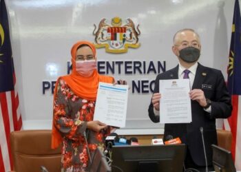 HALIMAH Mohamed Sadique bersama Wee Ka Siong menunjukkan garis panduan SOP sempena sambutan Tahun Baru Cina 2022 di Putrajaya. - UTUSAN/FAISOL MUSTAFA