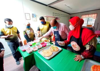 RASMAN Ithnain (dua dari kanan) melakukan demonstrasi membuat pizza sambil ditunjuk ajar oleh Suliza Suriat di kedainya di Felda Simpang Waha, Kota Tinggi di Johor. -UTUSAN/MASTURAH SURADI