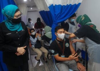 HASHIMAH Hashim (kiri) meninjau pemberian vaksin kepada kakitangan PjH pada Program MYMedic@Wilayah Vaccine Mobile Truck di Menara PjH, Putrajaya. - UTUSAN/FAISOL MUSTAFA