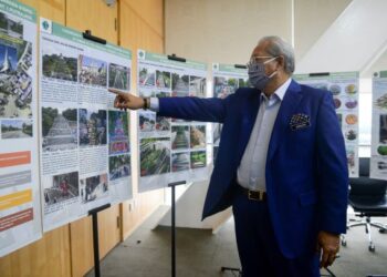 ANNUAR Musa melihat lakaran Tapak Projek Glamping@Wetland Putrajaya di Perbadanan Putrajaya, hari ini.- UTUSAN/FAISOL MUSTAFA