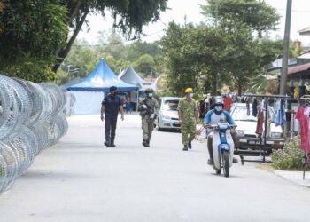 ANGGOTA Polis Diraja Malaysia (PDRM) bersama anggota ATM dan RELA mengawal laluan keluar masuk di sekitar kawasan Taman Murni, Sepang berikutan pelaksanaan PKPD. - UTUSAN/FAISOL MUSTAFA