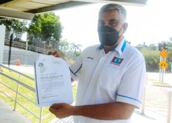 MANSOR Shah Golbat Shah menunjukkan laporan berhubung salah laku Idris Haron di perkarangan ibu pejabat SPRM, Putrajaya. -UTUSAN/FAISOL MUSTAFA