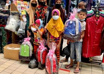 NOR Adini Badrul Din (dua dari kiri) bersama anak-anaknya dengan kelengkapan baharu sekolah yang disumbangkan Jabatan Pendidikan Negeri Perlis serta Yayasan Pok dan Kassim di Kangar, Perlis semalam. 
– UTUSAN/MOHD. HAFIZ ABD. MUTALIB