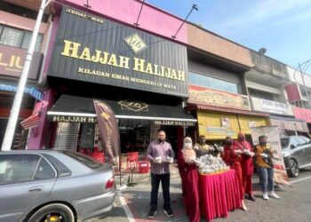 MOHD. Shaiful Hasri Shukri (kiri) bersama kakitangannya mengagihkan bubur lambuk percuma di hadapan kedai emas Hajjah Halijah di Kangar, Perlis semalam. – UTUSAN/NAZLINA NADZARI