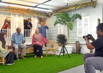 PEMILIK IPhoto Studio, Nurul Fariz Jamil (kanan) mengambil gambar sebuah keluarga di IPhoto Studio, Jalan Kampung Pondok, Kangar, Perlis, semalam. - FOTO/IZLIZAN OTHMAN