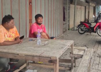 DUA pengusaha teksi motosikal berehat kerana kekurangan penumpang menggunakan perkhidmatan mereka di Padang Besar, Perlis semalam. – UTUSAN/SYED AZLAN SAYID HIZAR