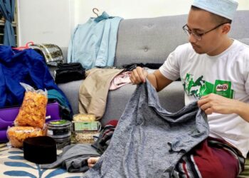 MUHAMMAD Zaim Redzuan mengemas barangan dan kelengkapan raya untuk pulang menyambut lebaran di kampung halaman di Arau, Perlis selepas dua tahun terpaksa beraya di ibu kota.- UTUSAN