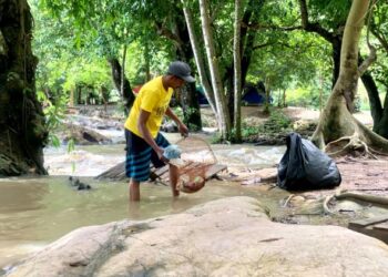 SALIKIN CHE SELIMEN mengutip  sampah tinggalan pengunjung di Bukit Jernih, Perlis semalam.- UTUSAN/ MOHD. HAFIZ ABD. MUTALIB