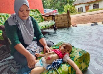 NAZIRA Kamat tabah menjaga anak bongsunya, Mohd. Airil 
ketika ditemui di Kampung Kurnia Diraja, Gemas, Tampin, semalam. – UTUSAN/NOR AINNA HAMZAH
