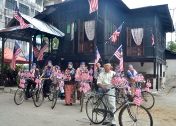 AZIZAN Darus (depan) dan sebahagian penduduk Kampung Bagan Ajam, Butterworth, Pulau Pinang bersama
basikal klasik yang dihiasi Jalur Gemilang sempena sambutan hari kemerdekaan tahun ini.