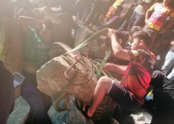 ANGGOTA Bomba dan Penyelamat Pulau Pinang menyelamatkan seorang wanita selepas kakinya tersepit di celah timbunan batu besar di Pantai Bagan Ajam, Butterworth malam tadi.- IHSAN BOMBA