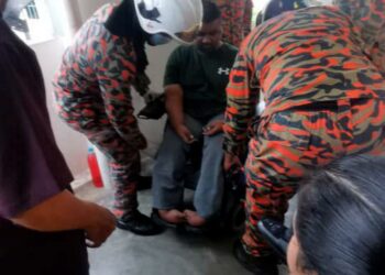 ANGGOTA bomba membawa turun pasangan beradik OKU menggunakan laluan tangga dari aras tiga Flat Sinar, Jelutong, Pulau Pinang semalam.