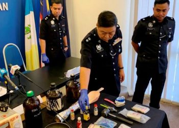 LEE Chong Chern meneliti kelengkapan memproses dadah yang dirampas dalam sidang akhbar di Ibu Pejabat Polis Daerah Seberang Perai Selatan, Pulau Pinang hari ini. -UTUSAN/SITI NUR MAS ERAH AMRAN