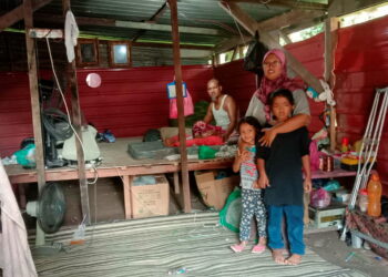 ROSMAN Darus, 45, dan Suzana Mansor, 35, bersama-sama dua anak mereka tinggal di dalam reban ayam yang diubah suai menjadi rumah di Balik Pulau, Pulau Pinang sementara menantikan kediaman baharu mereka siap. -UTUSAN/NOOR HASLIZA NUSI