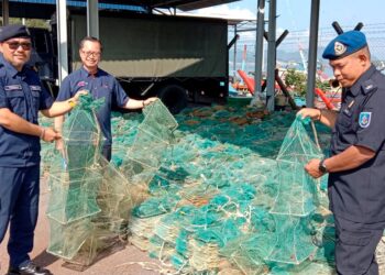 OSMAN Mohamed (kiri) menunjukkan bubu naga yang dirampas dalam Operasi MCS selama lima hari bermula Isnin lalu di Pangkalan Utama MCS Kampung Acheh, Sitiawan.
