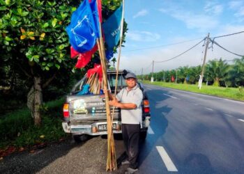 HAMZAH Samsudin mengutip buluh bendera parti politik untuk dibuat kraf di kem motivasi miliknya di Hutan Melintang di Bagan Datuk baru-baru ini. -UTUSAN