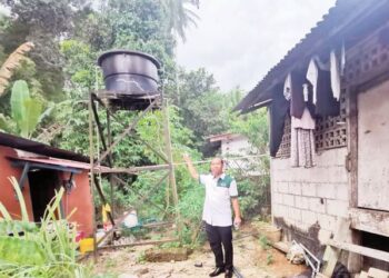RANI Bah Ulin menunjukkan tangki menyimpan air sungai untuk keperluan penduduk di Kampung Orang Asli Kampung Lata Kinjang di Tapah. - UTUSAN/AIN SAFRE BIDIN