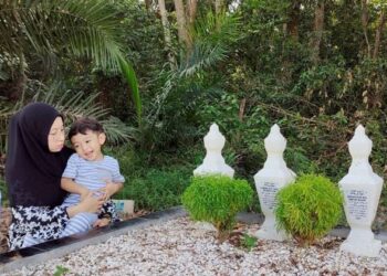 SHAMSHIRA Mohamad Norizin dan anaknya, Adeeb Hud Hafize menziarahi kubur suami dan anaknya di Chenderong Balai dekat Teluk Intan, Perak, baru-baru ini.