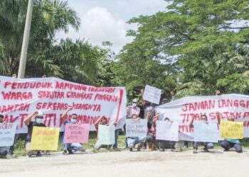 PENDUDUK, nelayan darat dan Orang Asli menunjukkan kain rentang menggesa agar aktiviti perlombongan dihentikan di kawasan mereka di Kampung Air Kuning, Kampung Gajah dekat Pasir Salak. - UTUSAN/MOHAMAD HAFIZI MOHD. SAID