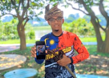 MUHAMMAD Yusof Bistamam menunjukkan gambar semasa berat badannya 160kg dan kini turun kepada 90kg setelah mengamalkan diet ketika ditemui di Kuala Kangsar. - UTUSAN/MOHAMAD HAFIZI MOHD. SAID