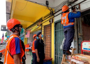 KAKITANGAN TNB memotong bekalan elektrik sebuah premis judi haram di Manjung, Lumut hari ini. -UTUSAN/SHAMSUL KAMAL AMARUDIN