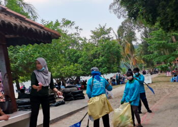 PEKERJA membersihkan sampah di Pantai Teluk Batik baru-baru ini. – UTUSAN/AIN SAFRE BIDIN