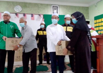 NOOR Azmi Ghazali (dua dari kanan) dan Exco Pendidikan negeri Perak, Razman Zakaria (kiri) menyampaikan sumbangan kotak bantuan makanan kepada penduduk di Bagan Serai hari ini. -UTUSAN/ WAT KAMAL ABAS