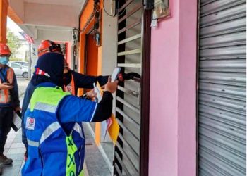 KAKITANGAN Tenaga Nasional Berhad (TNB) memotong bekalan di premis yang menjalankan aktiviti perjudian haram di Seri Iskandar, Perak. -GAMBAR IHSAN PDRM