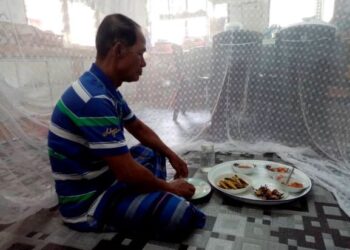 MOHAMAD Yusof Din terpaksa makan di dalam kelambu bagi mengelak ‘diserang’ lalat di rumahnya di Trong
dekat Bukit Gantang. – UTUSAN/MOHAMAD HAFIZI MOHD SAID