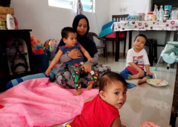 SAIZANA Ermah Hamdan menjaga tiga anaknya yang merupakan OKU di Simpang Tiga, Rungkup di Bagan Datuk. – UTUSAN/AIN SAFRE BIDIN