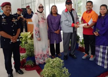 Kamaruddin Mat Desa  (tengah) menyampaikan sumbangan kepada Sarjan Norihan Tari (dua dari kanan) dan balu Sarjan Baharuddin Ramli, Relow Ko (tiga dari kiri) di Bidor, Tapah hari ini. -UTUSAN/ZAKI SALLEH