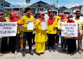 HAMIDAH Osman (tengah) menunjukkan laporan polis berkenaan Tanah Rizab Melayu yang dipindah milik kepada bukan Melayu di Ibu Pejabat Polis Daerah (IPD) Ipoh di sini hari ini. -UTUSAN/ ASLIZA MUSA
