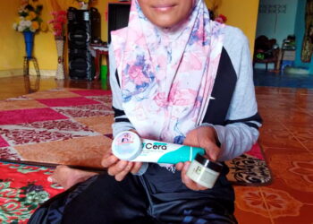 ROSMAYATI Toha menunjukkan krim ubat untuk penyakit kulit yang dideritainya sejak dua tahun lalu ketika ditemui di Felda Nenering, Pengkalan Hulu baru-baru ini. - UTUSAN/NORLIA RAMLI