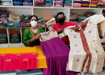 PAGIAH Laxmy Nakarogh bersama suaminya menunjukkan kain sari dan baju Punjabi yang dijual sempena Deepavali tahun ini di Teluk Intan. – UTUSAN/AIN SAFRE BIDIN