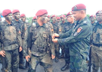 ROSMAN Kasman (kanan) melekatkan lencana bahu BN 3 PGA pada seorang anggota baharu Senoi Praaq di kem pasukan itu di Bidor, Perak. - UTUSAN/ZAKI SALLEH