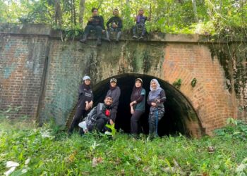PESERTA eksplorasi bergambar di hadapan satu daripada terowong kereta api lama di Bukit Berapit dekat Padang Rengas, Perak, baru-baru ini. - UTUSAN/WAT KAMAL ABAS